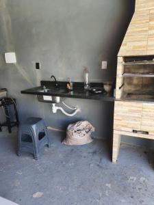 Una habitación con un mostrador, un lavabo y un taburete. en Chácara Baruk, en Iranduba