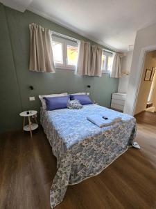een slaapkamer met een bed met een blauw dekbed en twee ramen bij Loft Fossati in La Spezia