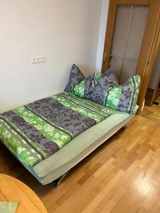 a bed in a room with green sheets and pillows at Tina`s Ferienwohnung in Kapfenberg