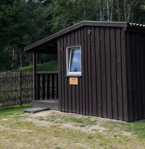 SaunagsにあるLĪVRĀNDA, Camping, Saunags ,Kolkaの窓と看板のある黒い小屋