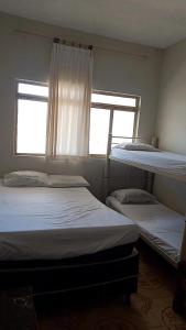 two bunk beds in a room with a window at Oeste Lapa Hotel in Bom Jesus da Lapa