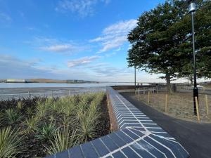 a sidewalk next to a body of water at Golden Oak Two bed Apartment in Erith