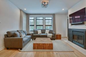 a living room with two couches and a fireplace at Tremblant mountain view in Mont-Tremblant