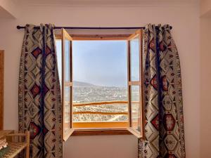 a window with a view of the desert at Tasga Guest House in Tamraght Ou Fella