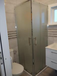 a glass shower in a bathroom with a toilet at Zacisze the Skuzos in Zdbice +13 photos