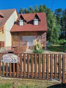 a house with a wooden fence in front of it at FYRED Vintage Apartman in Tiszafüred