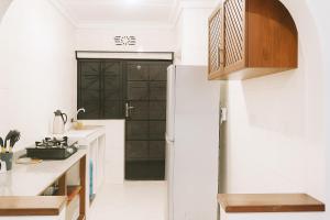 a kitchen with white walls and a black door at Villa Malkia's in Enaboishu