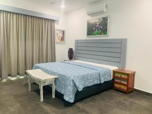 a bedroom with a bed and a table and a chair at Villa Ballena de Uvita in Uvita +6 photos