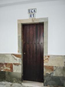 a wooden door in a building with a sign on it at Vivienda Vacacional Casa Uca in San Pedro