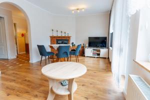 a living room with a table and chairs and a kitchen at Pokoje Gościnne OAZA in Sztutowo
