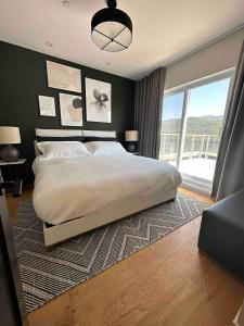 a bedroom with a large bed and a large window at Tremblant mountain view PH71 in Mont-Tremblant