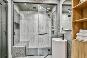 a bathroom with a shower and a white sink at Tremblant mountain view PH71 in Mont-Tremblant +40 photos