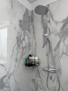 y baño con ducha y pared de mármol. en Stilvolle Wohnung Feel Good, en Gummersbach