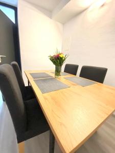 艾兴策尔Barock Living Fulda的一张带椅子的木桌和花瓶