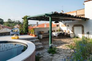 a backyard with a swimming pool and a pergola at Casa Trebaruna - refúgio numa aldeia do interior in Proença-a-Velha
