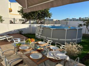 een tafel en stoelen met een fruitschaal en een zwembad bij Casa Maria Beatriz in Manta Rota