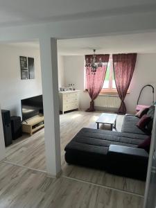 a living room with a couch and a table at Apartament blisko lotniska z prywatnym ogrodzonym parkingiem in Radom