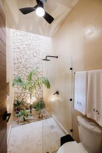 Un baño con ducha con pared de piedra. en Casa Naran centro Mérida, en Mérida