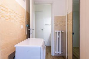 a small bathroom with a white refrigerator and a shower at Hotel Lugano in Milan