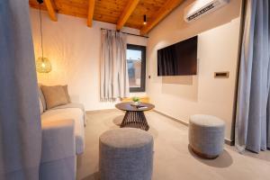 a living room with a couch and a tv at Etheras 2 - Holiday Apartments in Asgourou +8 photos