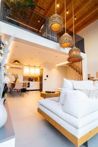 a living room and dining room with a white couch at Etheras 2 - Holiday Apartments in Asgourou