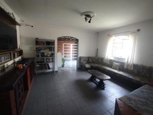 a living room with a couch and a window at Suítes e café Recanto da Árvore in Arraial do Cabo