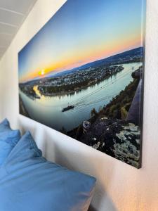 un tableau accroché au mur à côté d'un lit dans l'établissement Rhine & Wine Apartment, à Coblence