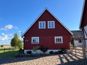 a red house with white windows and a fence at Frejagården Ängelholm in Ängelholm