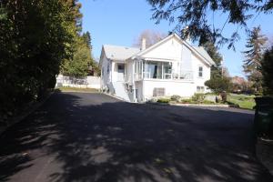 a white house with a driveway at Victoria Gorge Waterway Vacation Home in Victoria