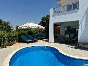 a swimming pool in front of a house at Alpha Five in Pissouri