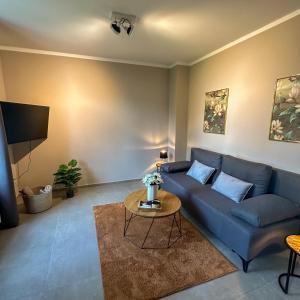 a living room with a blue couch and a table at Uferresidenz Altbau mit Kanalblick und Parkplätzen in Oldenburg