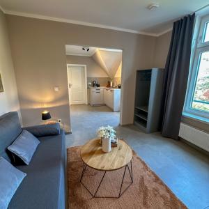 a living room with a blue couch and a table at Uferresidenz Altbau mit Kanalblick und Parkplätzen in Oldenburg