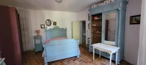 a bedroom with a blue bed and a table at Maison à Cadillac avec jardin in Cadillac