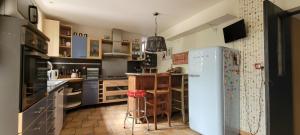 a kitchen with a refrigerator and a table in it at Maison à Cadillac avec jardin in Cadillac