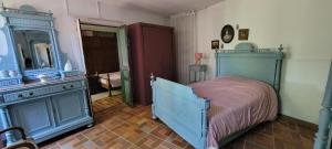 a bedroom with a blue bed and a mirror at Maison à Cadillac avec jardin in Cadillac