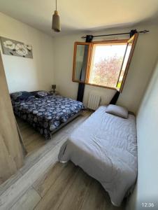 a bedroom with two beds and a window at Un Havre de Calme - proche Ferme de la Doudou in Cheptainville