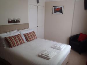 a bedroom with a bed with two towels on it at Clinmore House in Paignton