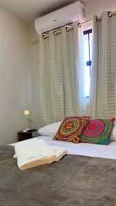 a bedroom with a bed with two pillows and a window at Studio Gilberto Machado in Cachoeiro de Itapemirim