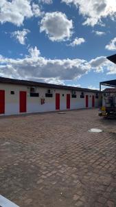 a large white building with red doors on it at JR POUSADA in Morro do Chapéu