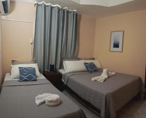 two beds in a hotel room with towels on them at Hotel Pensión Galicia in Obaldía