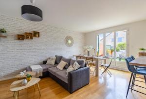 a living room with a couch and a table at Jardin suspendu - 3 chambres - 2 salles de bain - Parking dans résidence privée in Charnay-lès-Mâcon