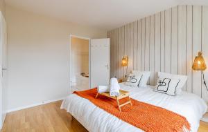 a bedroom with a large white bed with an orange blanket at Jardin suspendu - 3 chambres - 2 salles de bain - Parking dans résidence privée in Charnay-lès-Mâcon