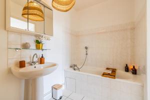 a bathroom with a sink and a bath tub at Jardin suspendu - 3 chambres - 2 salles de bain - Parking dans résidence privée in Charnay-lès-Mâcon +20 photos