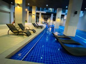 马尼拉Condotel at S Residences near SM MOA, SMX, Arena, NAIA Airport的一座带椅子的建筑中的游泳池