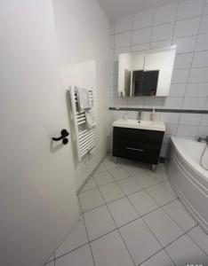 a white bathroom with a sink and a mirror at Un Havre de Calme - proche Ferme de la Doudou in Cheptainville