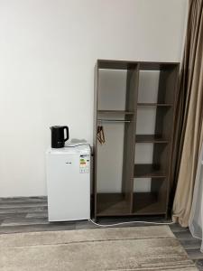 a white refrigerator next to a book shelf at Guest house Stella in Cholpon-Ata