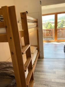 a room with bunk beds and a door with a window at Les Chalets De Superd Bleuet - 2 Pièces pour 6 Personnes MAE-8844 in Le Dévoluy