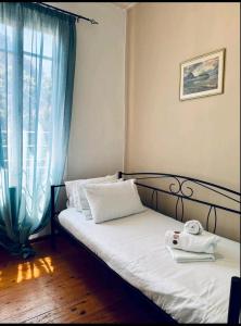 una camera con un letto, una finestra e un telefono di Maison Konstantinos a Nauplia