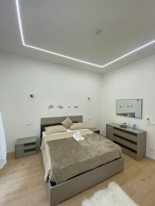 a white bedroom with a bed and a tv at Mare Montenotte in Savona