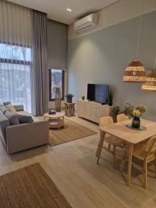 a living room with a couch and a table at Beach Villa mit Privatpool, Dachterrasse in Ma‘mūrah